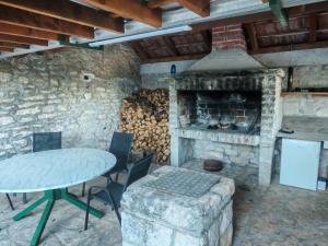 a stone kitchen with a table and a fireplace at Božini dvori in Drniš