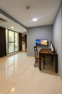 a living room with a table and a tv at Al Amer Palace Hotel in Amman +19 photos