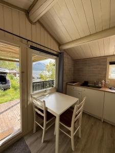 a kitchen with a table and chairs in a tiny house at Fagervik Camping in Tresfjord