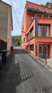 an empty street in front of a orange building at La Maison Douce Lourdes in Lourdes
