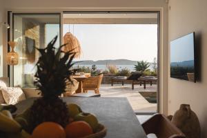 a living room with a table with a bowl of fruit at Villa Ammos with Private Pool, Sauna & Seaview in Gialova