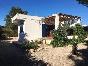a small white house with a wooden roof at Villa del Pi in L'Ametlla de Mar
