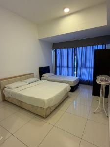 a bedroom with two beds and a window with blue curtains at aloha homestay in Miri