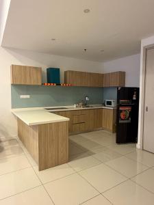 a kitchen with wooden cabinets and a black refrigerator at aloha homestay in Miri