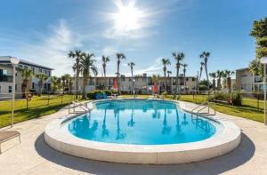 a large swimming pool in a park with palm trees at Sea Palm G in Fort Walton Beach