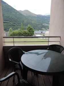 una mesa y sillas en un balcón con vistas en Les Gloriettes, en Luz-Saint-Sauveur