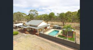 an overhead view of a house with a swimming pool at Whispering Woods Pool Sauna in Maryborough