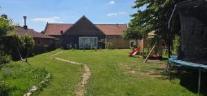 a yard with a playground and a house at Bij de Salamandras in Stramproy