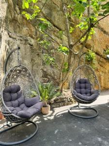 two chairs sitting in front of a stone wall at Hôtel de l'Ecluse in Neuchâtel