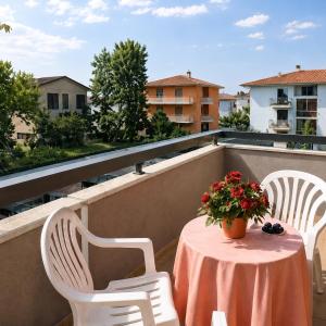 a table and chairs on a balcony with a table and flowers at Adria Residence in Gatteo a Mare