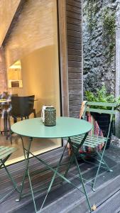 a green table sitting on a porch with a basket at Hôtel de l'Ecluse in Neuchâtel