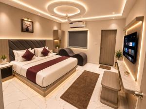a hotel room with a bed and a flat screen tv at Hotel VAAYU Stay IGI Airport in New Delhi