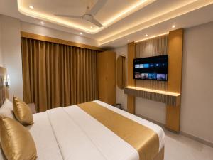 a bedroom with a large bed and a flat screen tv at Hotel VAAYU Stay IGI Airport in New Delhi