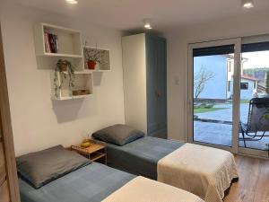 two beds in a room with a window at DOMKI , Pokoje gościnne Ustronie in Zwierzyniec