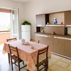 a kitchen with a table with chairs and a refrigerator at Adria Residence in Gatteo a Mare