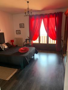 a bedroom with red curtains and a bed and a window at Casa cesari in Ajaccio