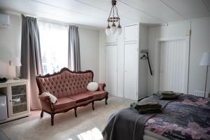 a bedroom with a red couch and a bed at Ruustinna Hotelli & B&B Majoitus in Saarijärvi