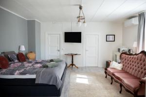 a bedroom with a bed and a couch and a tv at Ruustinna Hotelli & B&B Majoitus in Saarijärvi +45 photos