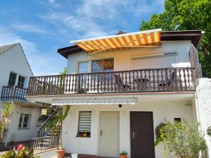 a house with a balcony with a surfboard on it at Ferienwohnung Am See 55 in Bad Saarow