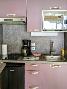 a kitchen with purple cabinets and a sink at Les Portes du Soleil Studio in Le Biot