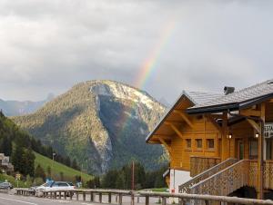 a rainbow over a mountain with a wooden building at Les Portes du Soleil Studio in Le Biot