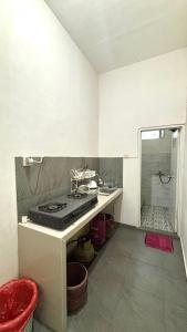 a kitchen with a sink and a stove in it at HARMONI GUEST HOUSE tumpak sewu in Sumberbopong +17 photos