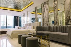 a hotel room with two beds and a couch at VMona Hotel in Thôn Kim Long (1)