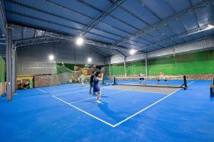 a group of people playing tennis on a tennis court at Tada Moc Chau - Villa & Local Kitchen in Mộc Châu