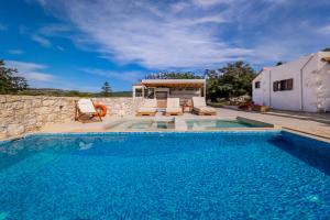 a swimming pool in front of a house at Minos Villa in Arménoi