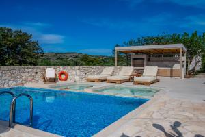 a swimming pool with chairs and a gazebo at Minos Villa in Arménoi +29 photos
