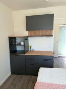 a kitchen with black cabinets and a counter top at South Harbour Studios in Vordingborg