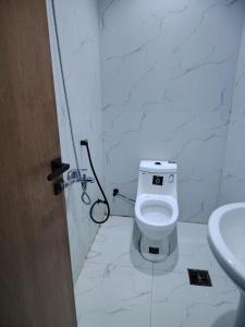 a white bathroom with a toilet and a sink at استديو داخل بناية حي النرجس in Riyadh