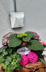 a planter with flowers and a white printer on a wall at Ferienhaus Waldblick in Hohenfels-Essingen