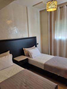 a bedroom with two beds and a chandelier at Appartement sselam fetouaki montagne view in Moulay Yacoub
