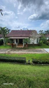 a house with a yard with a grass yard sidx sidx sidx at Chaya village B - a shared pool & Jacuzi in Ko Lanta