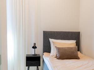 a bed with a pillow and a lamp on a night stand at Ruustinna Hotelli & B&B Majoitus in Saarijärvi