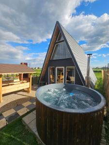 a large hot tub in front of a house at Elioan Cozy A-Frame in Mărăcineni
