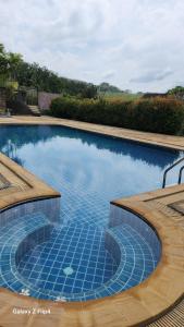 a large swimming pool with blue tiles on it at Chaya village B - a shared pool & Jacuzi in Ko Lanta