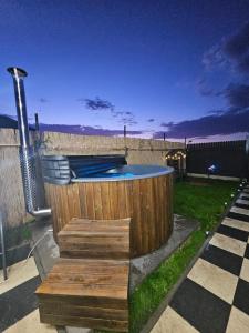 a pool in a backyard with a wooden fence at Elioan Cozy A-Frame in Mărăcineni