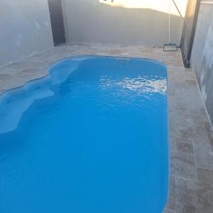 a swimming pool with blue water in a house at Ti nae in Étang-Salé