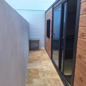 a hallway with glass doors and a table at Ti nae in Étang-Salé
