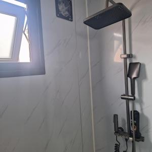 a shower in a bathroom with a light on the wall at Ti nae in Étang-Salé