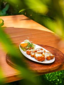 a plate of food on a wooden table at Vinsons Cottages in Colva