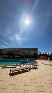 a patio with tables and benches in front of a building at Baytur Resort таунхаус in Bosteri