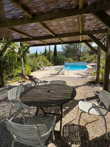 a wooden table and chairs under a wooden pergola at Domaine de Villedese in Montlaur