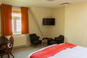 a bedroom with a bed and two chairs and a tv at Central Bruges B&B in Bruges +16 photos