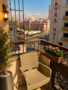 a balcony with a chair and flowers on a building at City View Museum Hotel in Cairo