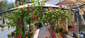 a pergola filled with flowers and plants at Kyperounta Troodos Mountain House! in Kyperounda