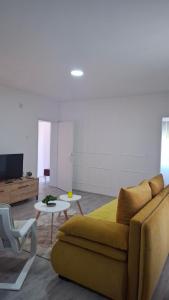 a living room with a couch and a table and a tv at SAMI APARTMAN in Niš +29 photos