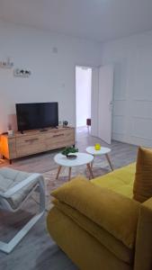 a living room with a couch and a tv at SAMI APARTMAN in Niš